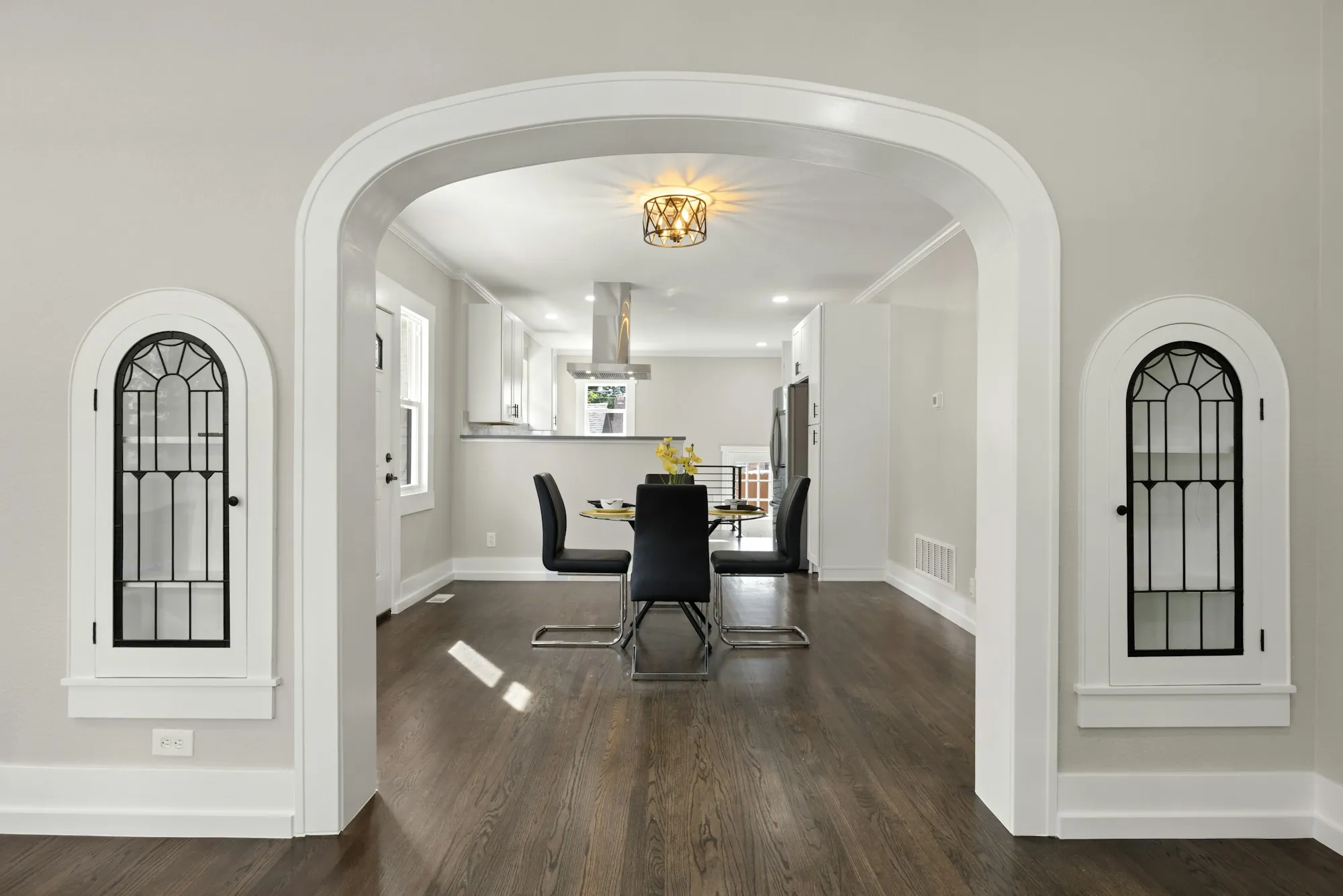 Arched doorway opening into a dining room and kitchen