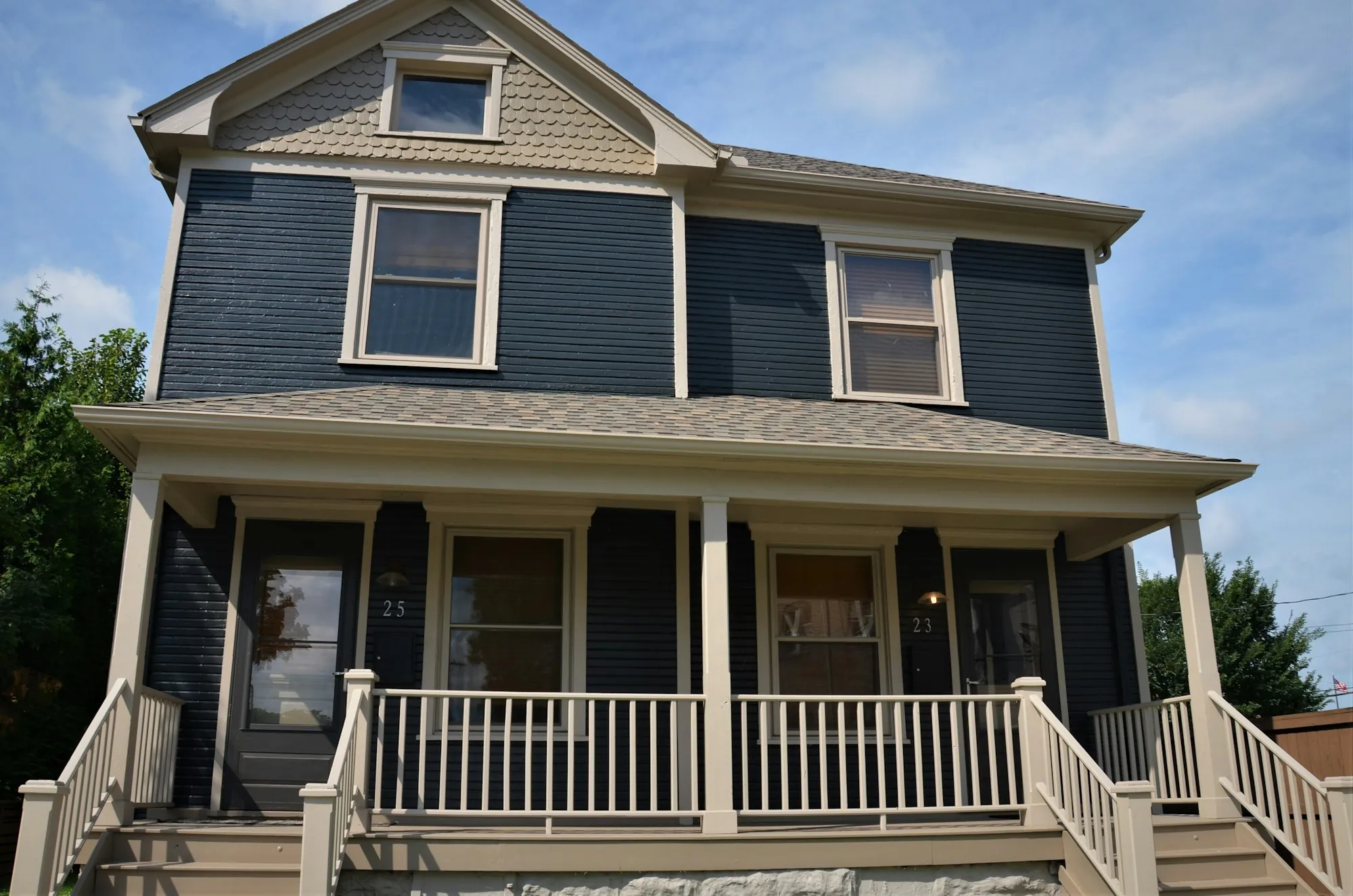 Blue two-story house with a full-width covered front porch